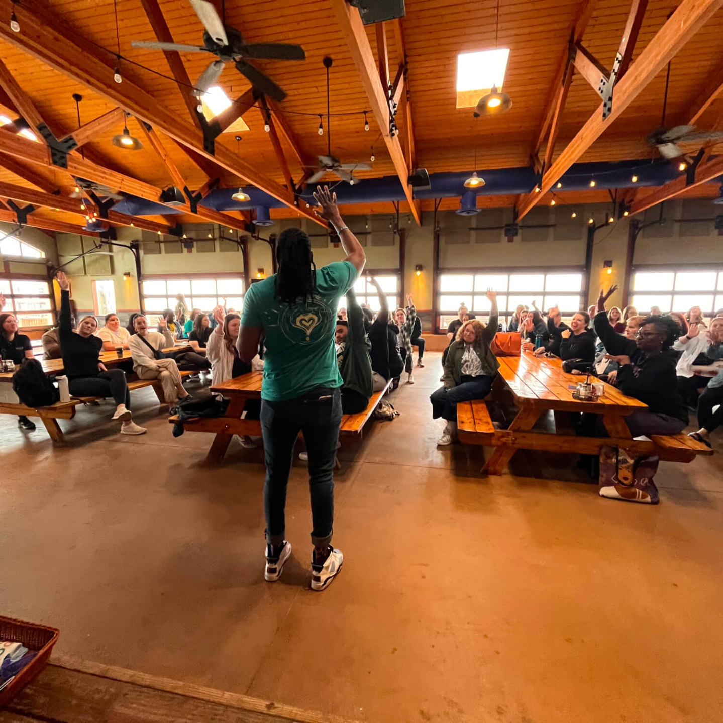 A training session with a group of people raising their hands.