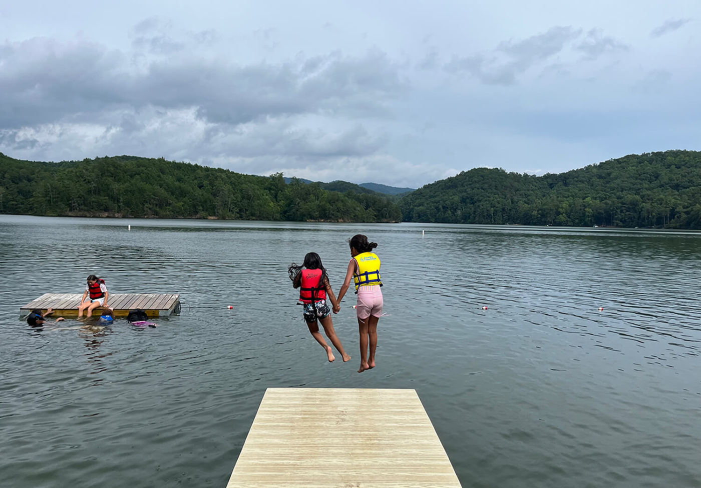 Two girls jumping into the river
