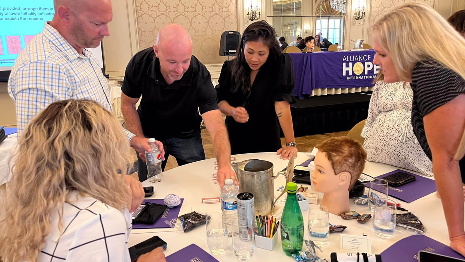 A group of people is gathered around a table, engaged in an interactive activity